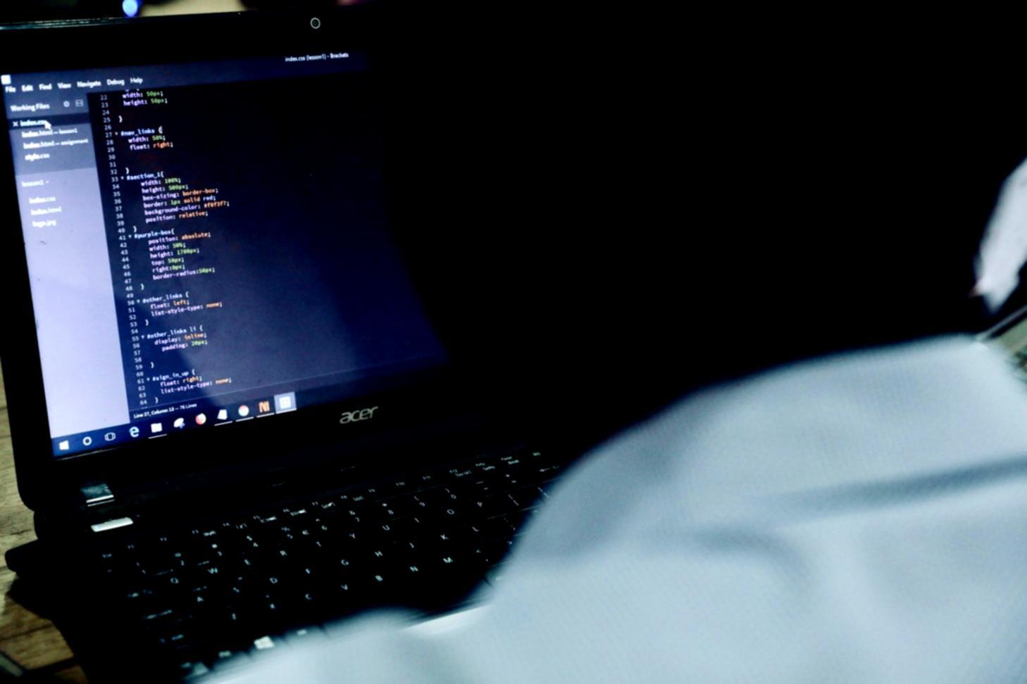 Persona trabajando en diseño UX con múltiples pantallas mostrando wireframes y prototipos